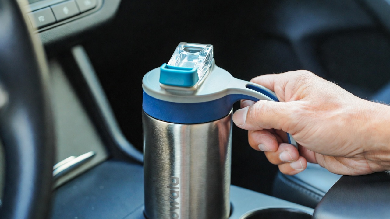 Owala FreeSip Sway 30 oz water bottle in Out of the Blue color, showing the 2-in-1 spout and ergonomic handle.