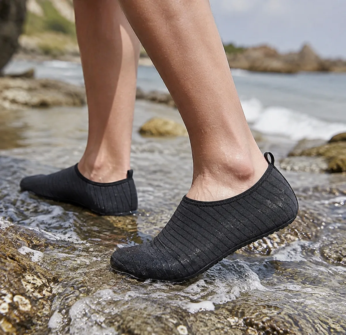 A pair of quick-dry water shoes on a rocky beach near the water